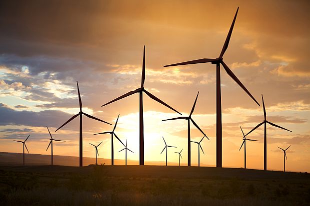 wind turbines generating electricity on sunset sky